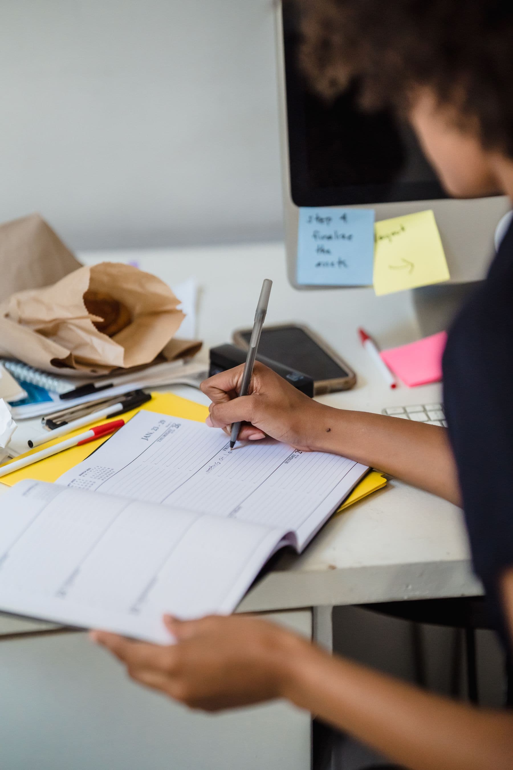A professional writing appointments in a desk planner