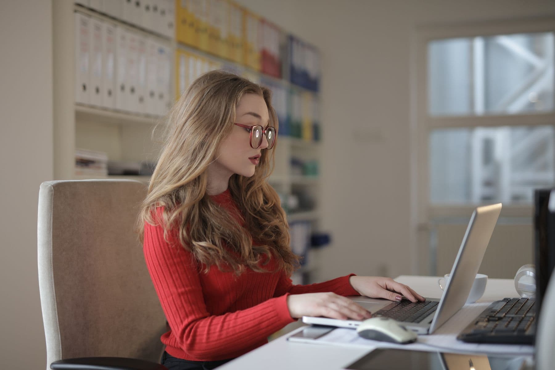 A professional working on a laptop at an organized desk