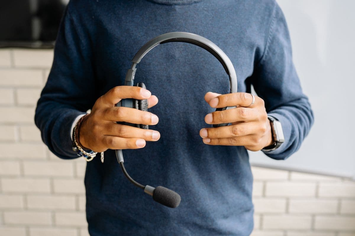 A customer support headset held beside a workstation