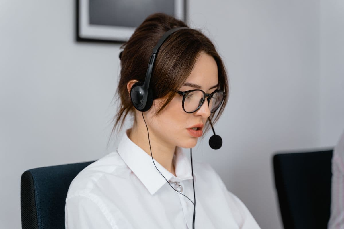 A support professional wearing a headset at a computer
