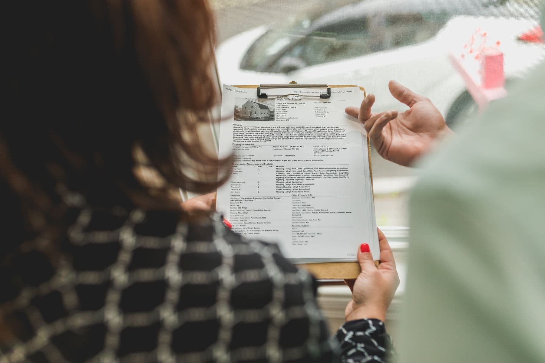 Two people reviewing a property information sheet